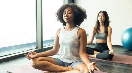 Woman relaxes and meditates in yoga studio with clean candles to scent the space